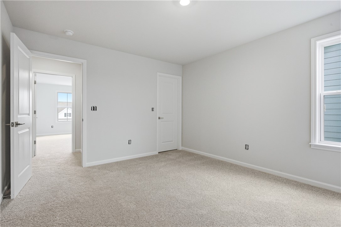 552 Hydrangea Street, Unit LOT 66 Seneca, SC 29678 - Photo 29 of 31 A spacious, naturally illuminated room featuring a light-colored carpet, offering a versatile blank canvas.