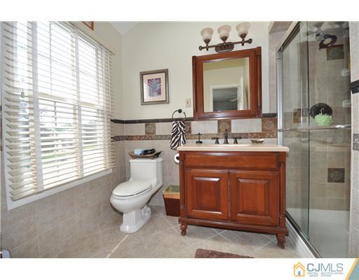 36 Higgins Road Old Bridge, NJ 08857 - Photo 8 of 12 a bathroom with a toilet a sink a mirror a window and vanity