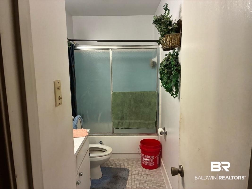 514 Nantucket Circle Mobile, AL 36609 - Photo 4 of 13 Bathroom featuring vanity, tile patterned flooring, enclosed tub / shower combo, and toilet
