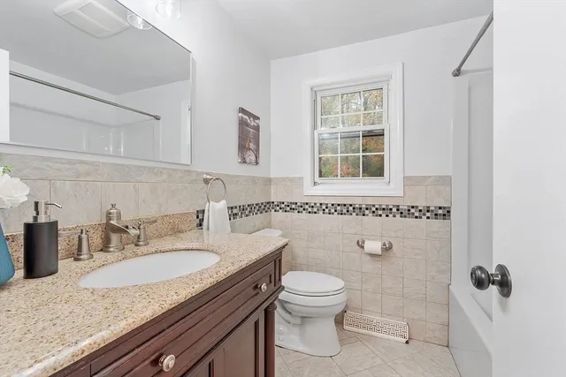 a bathroom with a granite countertop sink toilet and shower