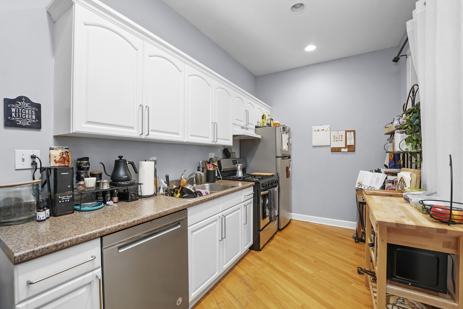 4363 North Lincoln Avenue Chicago, IL 60618 - Photo 11 of 34 a kitchen with stainless steel appliances granite countertop a stove a sink dishwasher and a refrigerator with wooden floor