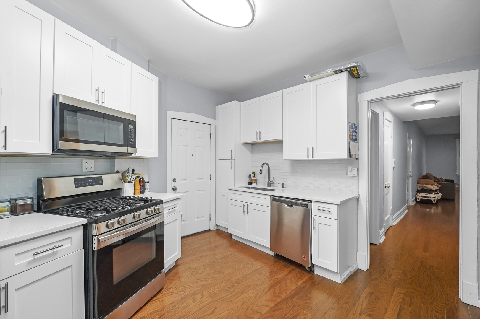4363 North Lincoln Avenue Chicago, IL 60618 - Photo 14 of 34 a kitchen with cabinets stainless steel appliances and wooden floor