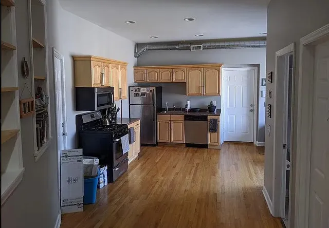 a kitchen with a refrigerator a sink and wooden floor
