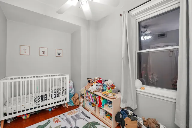 a bedroom with baby bed toys and paintings on the wall