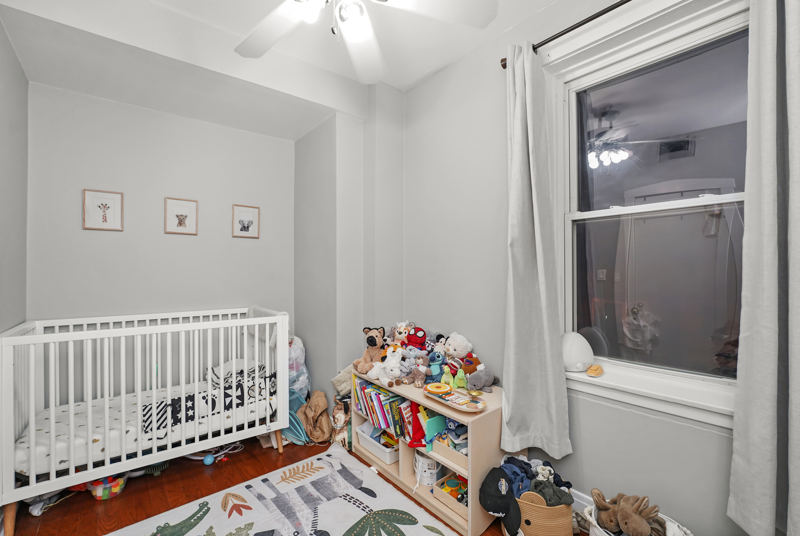 4363 North Lincoln Avenue Chicago, IL 60618 - Photo 30 of 34 a bedroom with baby bed toys and paintings on the wall