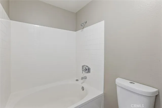 a white bath tub sitting next to a white toilet