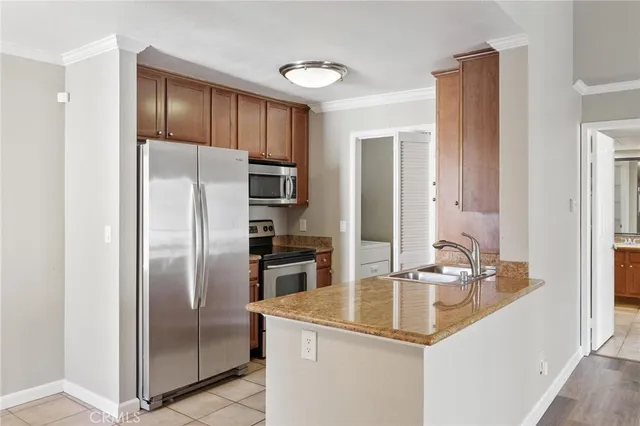 a kitchen with kitchen island a counter top space cabinets and stainless steel appliances