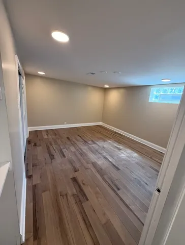 an empty room with wooden floor and windows in it