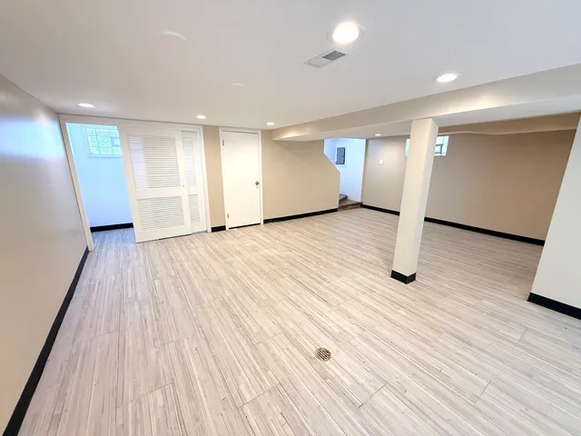 a view of an empty room with wooden floor