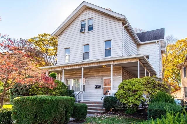 a front view of a house with plants