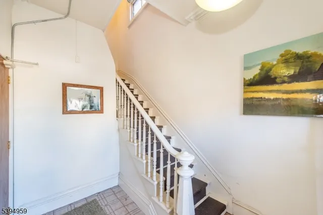 a view of a hallway with wooden floor and a bathroom