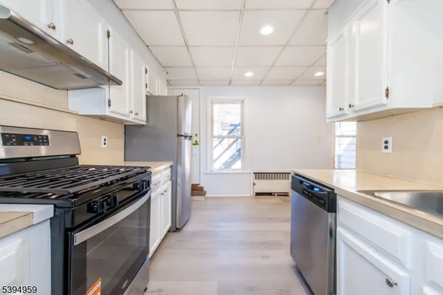 a kitchen with granite countertop a sink stove and refrigerator