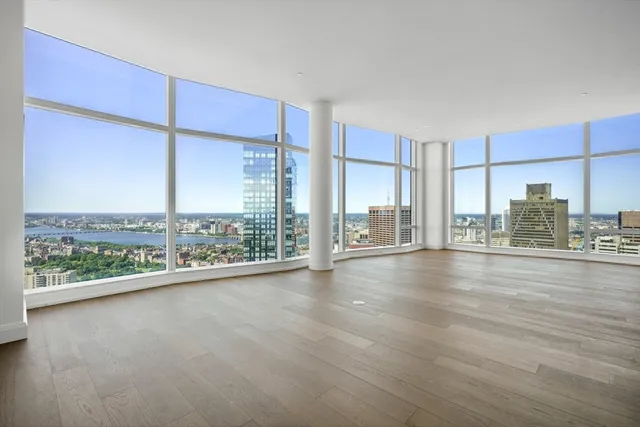 a view of a living room hardwood floor and an empty room