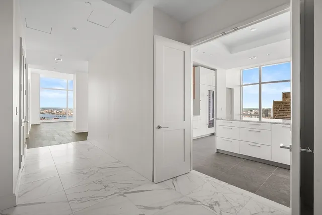 a large white bathroom with a granite countertop sink a mirror and a bathtub