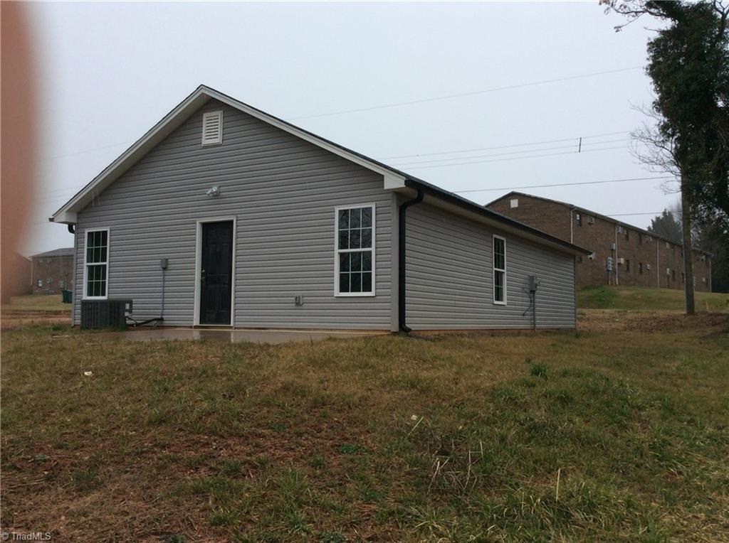 7739 Pine Street Rural Hall, NC 27045 - Photo 13 of 33 Rear Right View: Here we can see the low maintenance vinyl exterior, thew heat pump and the rear door to a concrete patio where you can sit out and relax after a busy day.