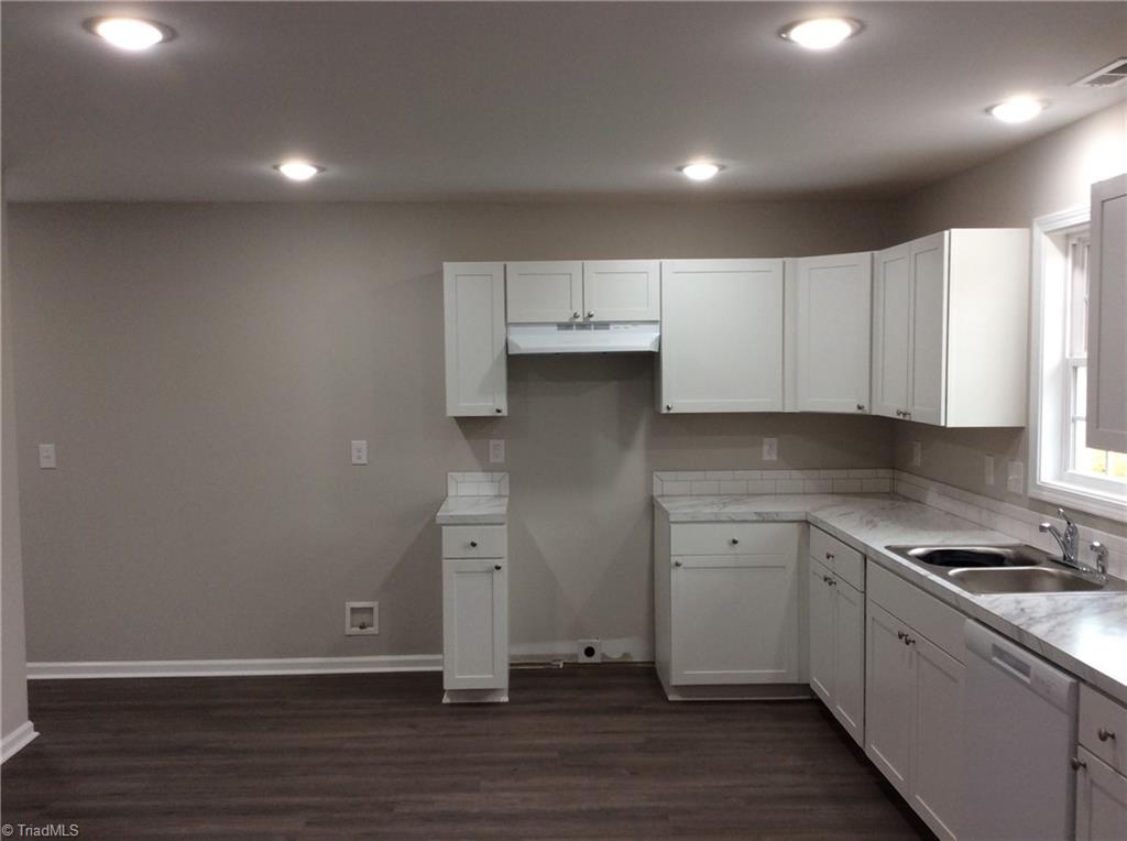 7739 Pine Street Rural Hall, NC 27045 - Photo 20 of 33 Kitchen: Features include vinyl plank flooring for easy cleaning, all new bright cabinets and counter tops, new fixtures, recessed lighting, fresh paint and a window over the sink so that you can see the outside world as you are cleaning up after that great dinner. To the left side is the laundry room.