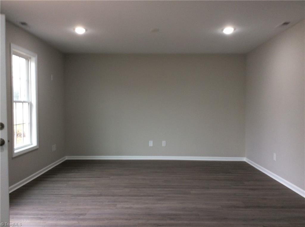 7739 Pine Street Rural Hall, NC 27045 - Photo 2 of 33 Living Room: Features include vinyl plank flooring for easy cleaning, a window for natural lighting, recessed lighting and fresh new paint.