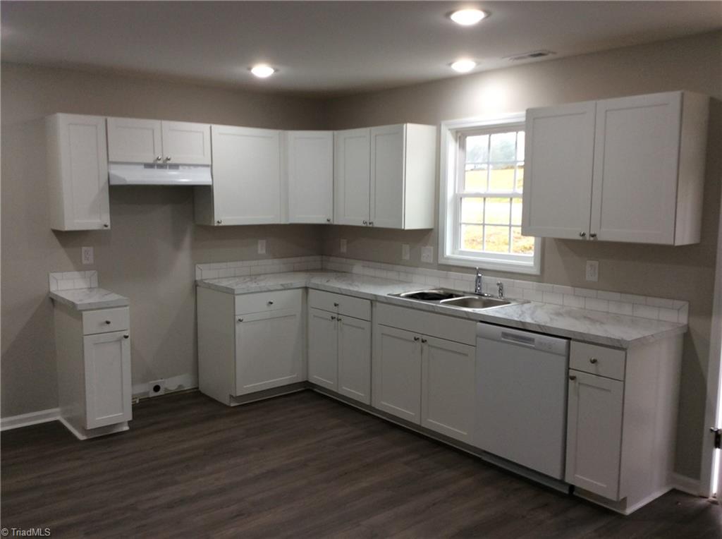 7739 Pine Street Rural Hall, NC 27045 - Photo 21 of 33 Kitchen: Features include vinyl plank flooring for easy cleaning, all new bright cabinets and counter tops, new fixtures, recessed lighting, fresh paint and a window over the sink so that you can see the outside world as you are cleaning up after that great dinner.