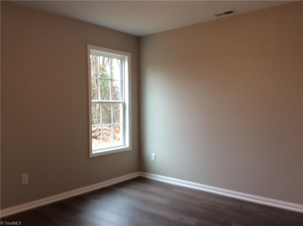 7739 Pine Street Rural Hall, NC 27045 - Photo 22 of 33 Primary Bedroom: Features include vinyl plank flooring for easy cleaning, a window for natural lighting and fresh new paint.