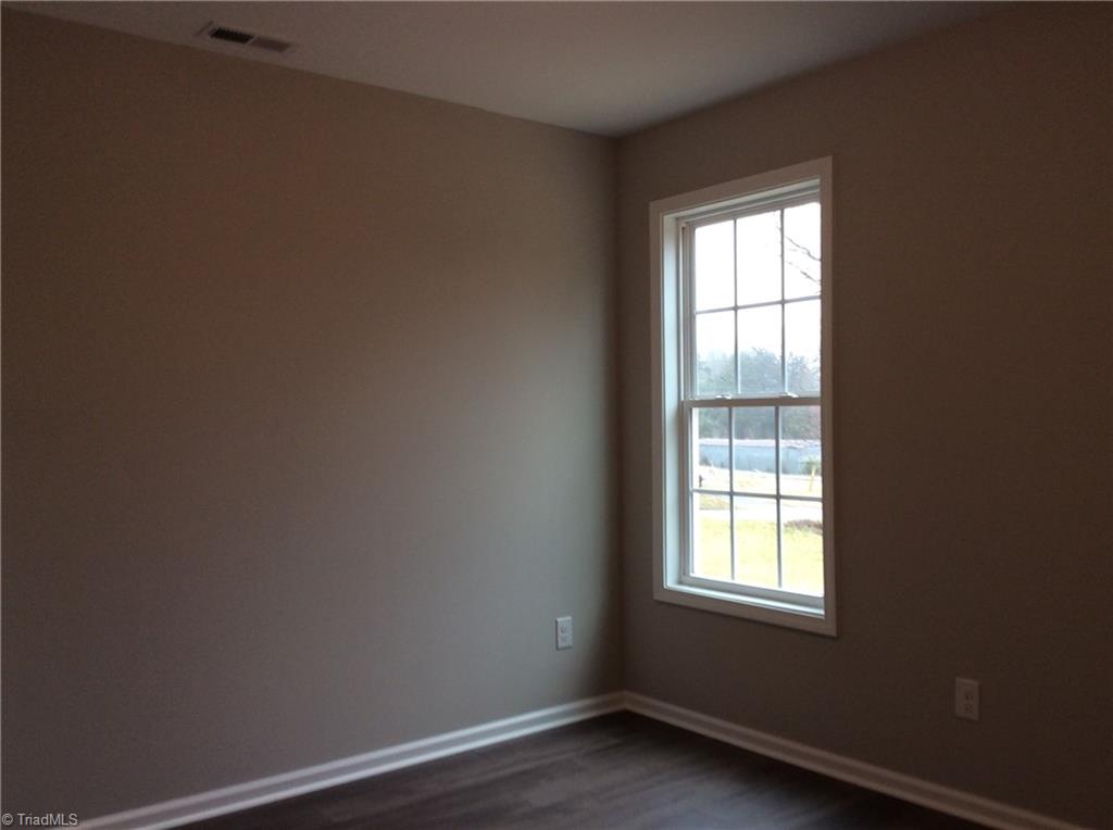 7739 Pine Street Rural Hall, NC 27045 - Photo 25 of 33 Bedroom 2: Features include vinyl plank flooring for easy cleaning, a window for natural lighting and fresh new paint.