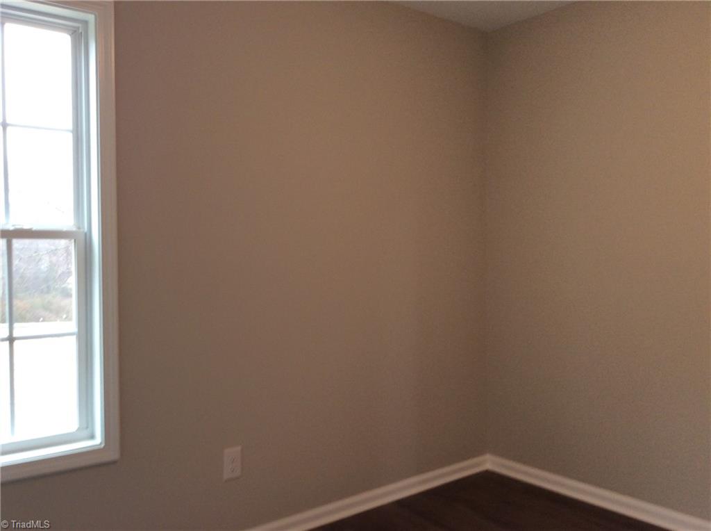 7739 Pine Street Rural Hall, NC 27045 - Photo 26 of 33 Bedroom 2: Features include vinyl plank flooring for easy cleaning, a window for natural lighting and fresh new paint.