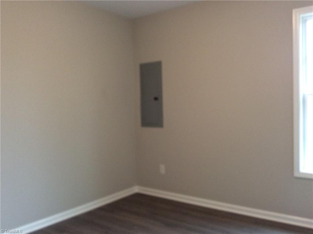 7739 Pine Street Rural Hall, NC 27045 - Photo 28 of 33 Bedroom 3: Features include vinyl plank flooring for easy cleaning, a window for natural lighting and fresh new paint.