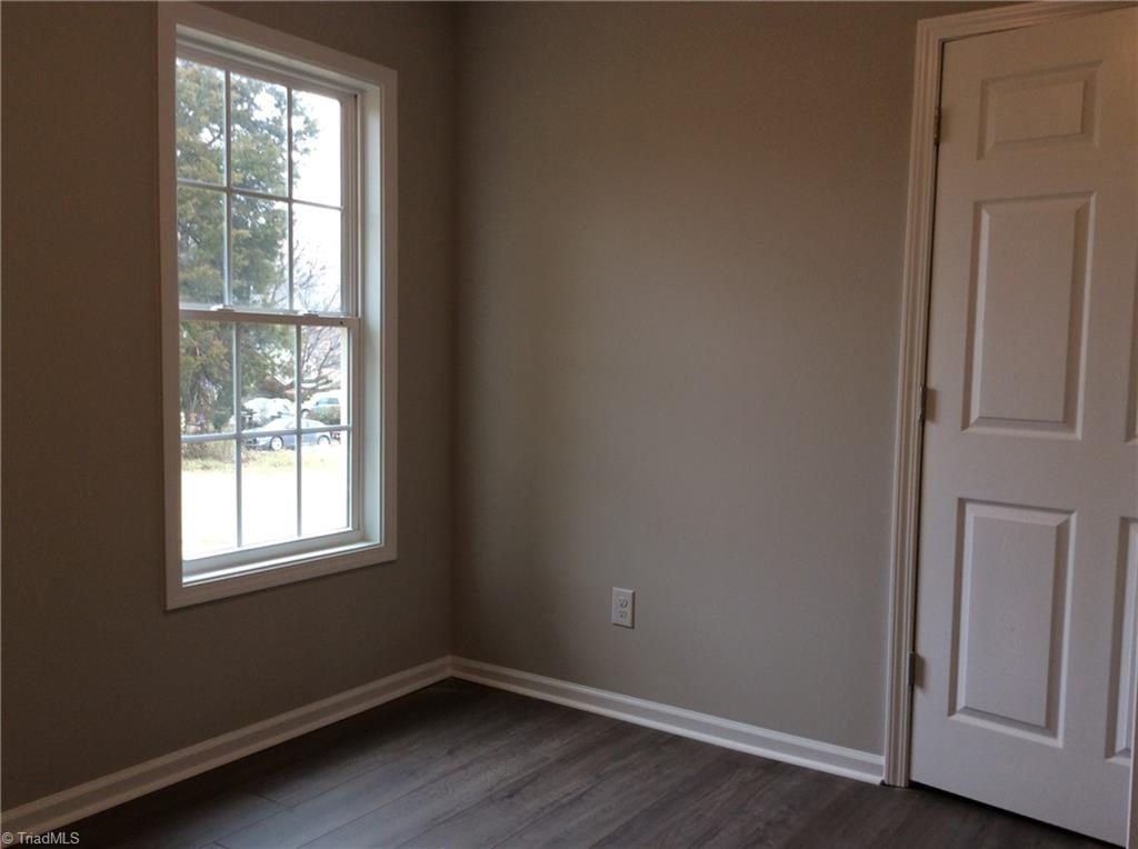 7739 Pine Street Rural Hall, NC 27045 - Photo 29 of 33 Bedroom 3: Features include vinyl plank flooring for easy cleaning, a window for natural lighting and fresh new paint. The closet is on the right side.