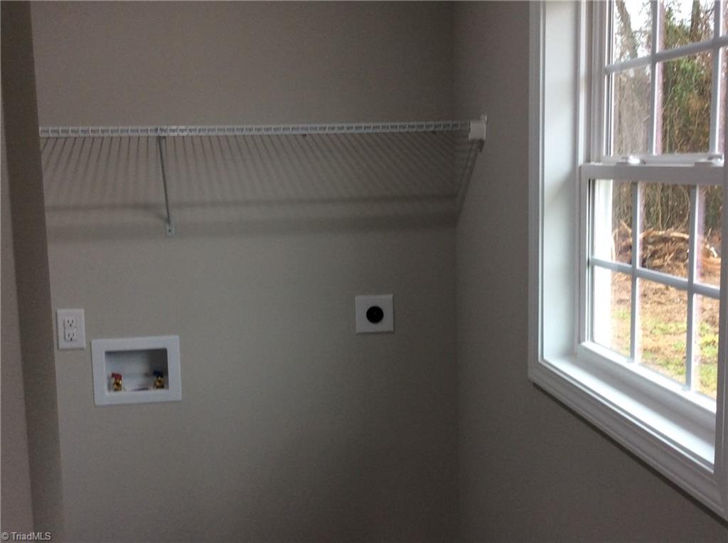 7739 Pine Street Rural Hall, NC 27045 - Photo 33 of 33 Laundry Room: Features include vinyl plank flooring for easy cleaning, all the hookups for your washer and dryer, a window for natural lighting and wire racks for your cleaning products.