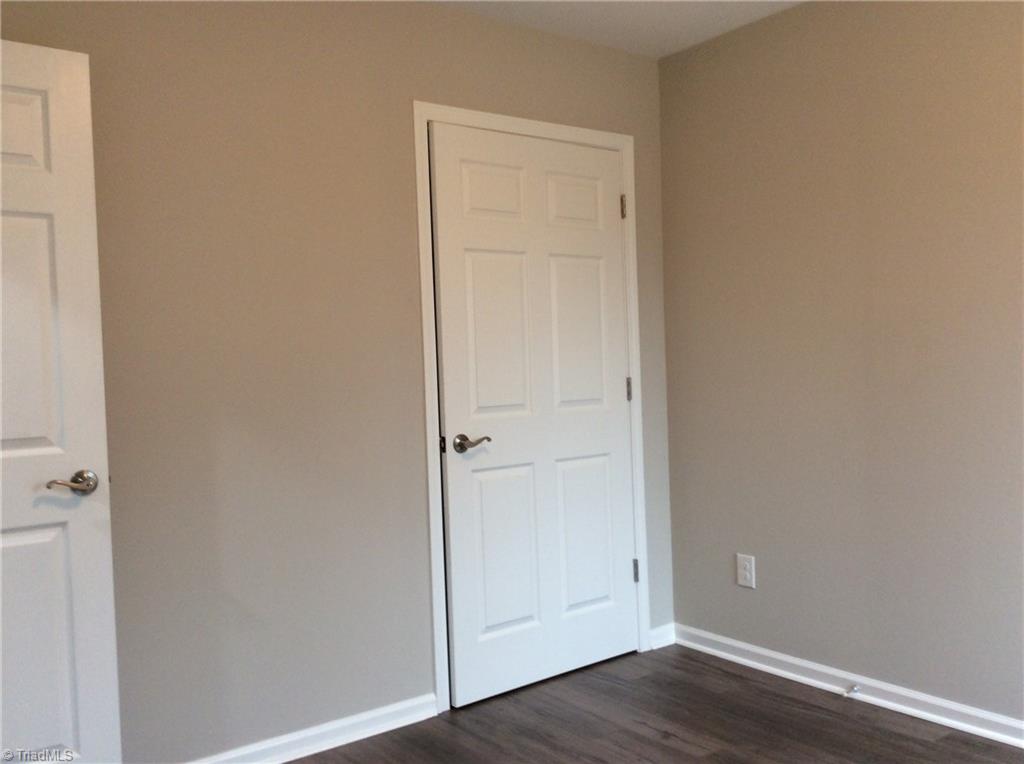 7739 Pine Street Rural Hall, NC 27045 - Photo 7 of 33 Bedroom 2: Features include vinyl plank flooring for easy cleaning, a window for natural lighting and fresh new paint. The open door on the left side is the entry door from the hallway and the closet is on the right side.