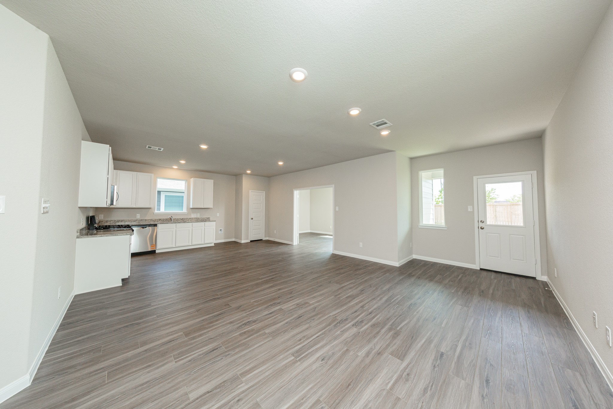 2540 Hawks Eye Drive Conroe, TX 77301 - Photo 4 of 18 a view of empty room with wooden floor and kitchen