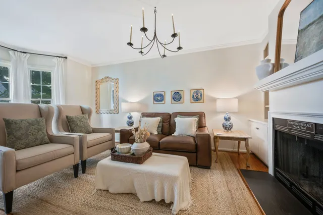 a living room with furniture a fireplace and a chandelier