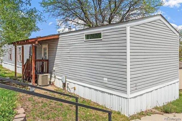 a view of a house with a small yard and large tree and wooden fence