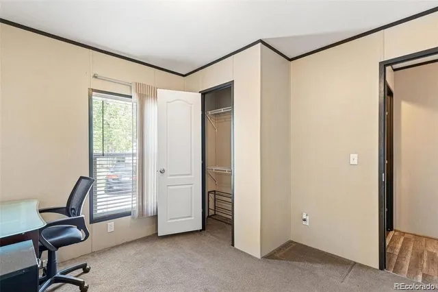 a view of a workspace with furniture and a window
