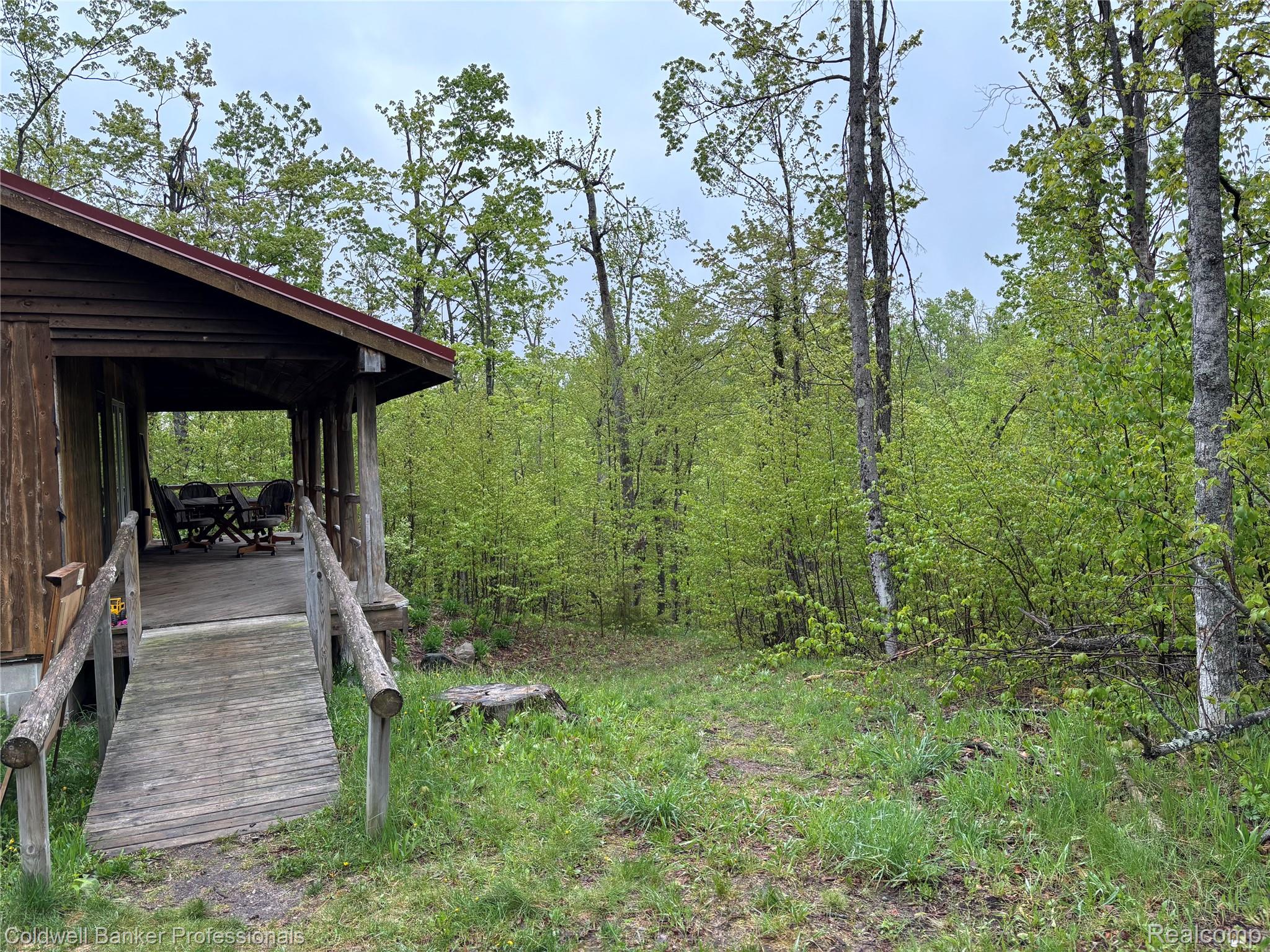 11560 Ashman Hl Road Boyne Falls, MI 49713 - Photo 13 of 22 Wood-sided cabin featuring a covered porch, wood plank decking, and a wood ramp entry