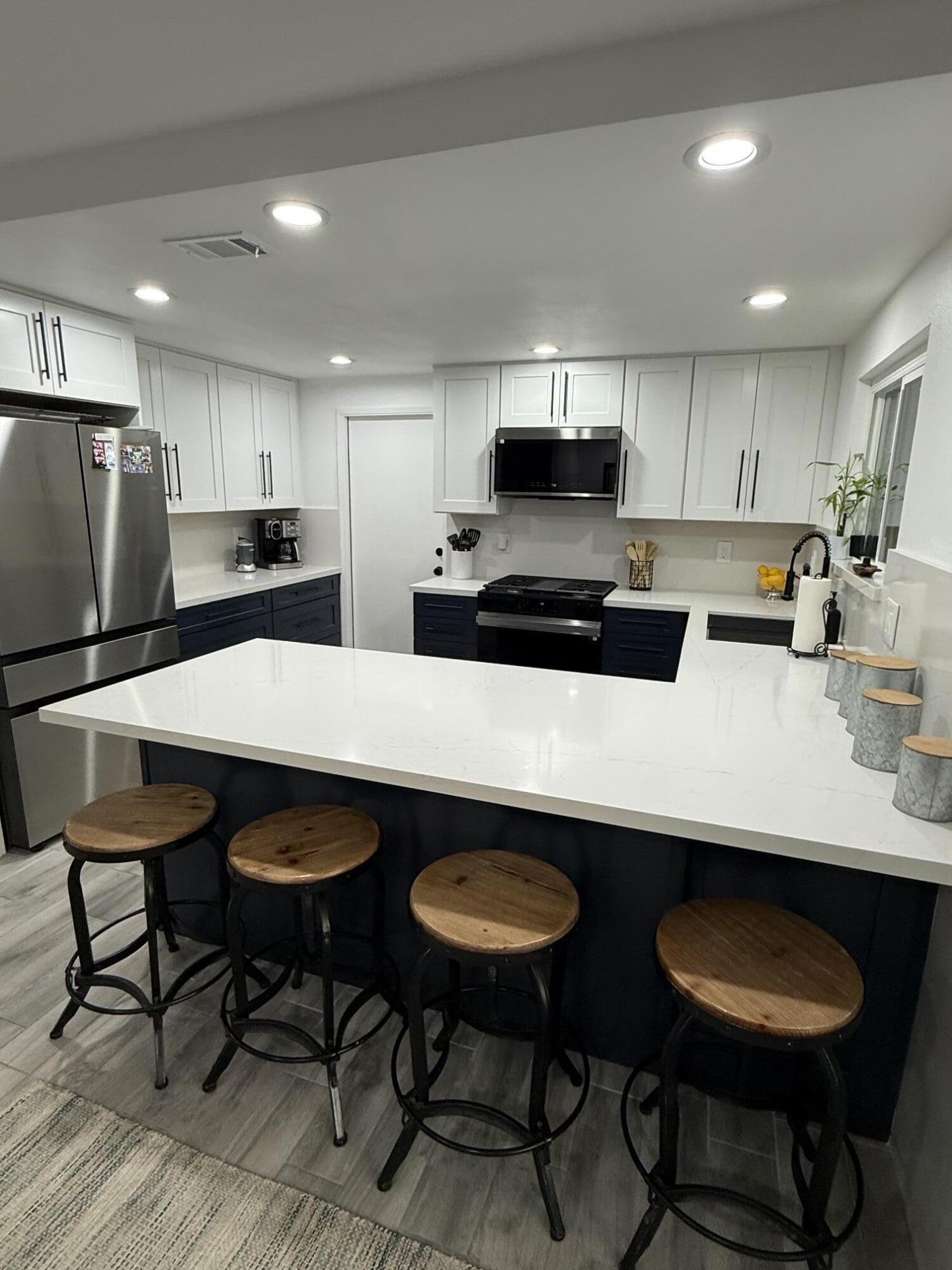 37081 Palmdale Road Rancho Mirage, CA 92270 - Photo 15 of 46 a kitchen with stainless steel appliances a table chairs refrigerator and microwave