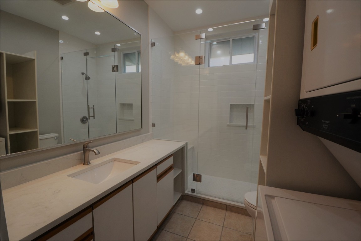 7602 Blessing Avenue Austin, TX 78752 - Photo 10 of 17 Full bathroom featuring stacked washer / drying machine, vanity, a shower stall, tile patterned floors, and recessed lighting