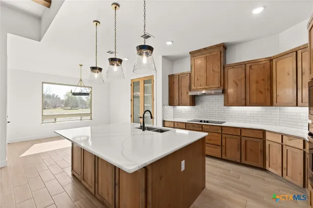 a kitchen with stainless steel appliances granite countertop a sink and a wooden floors