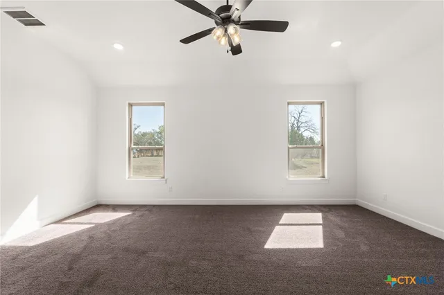 an empty room with a window and a fan