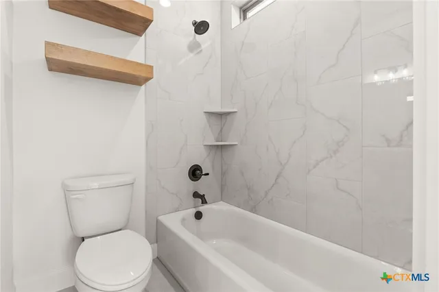 a white toilet sitting next to a bath tub