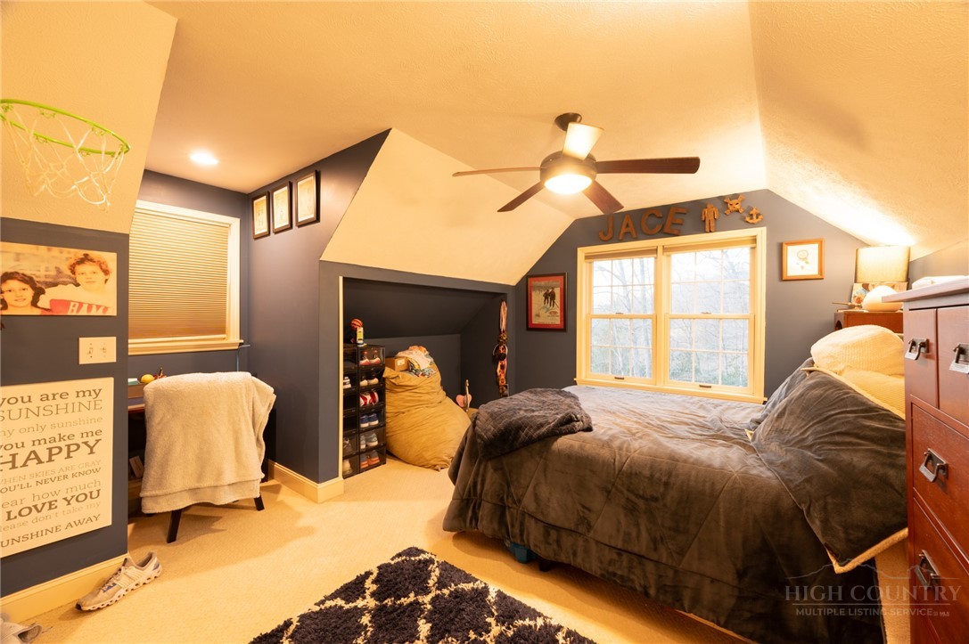 126 Moore Mountain Road Vilas, NC 28692 - Photo 22 of 41 a bedroom with a bed and a chandelier