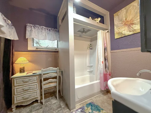 a bathroom with a sink a bathtub and a window