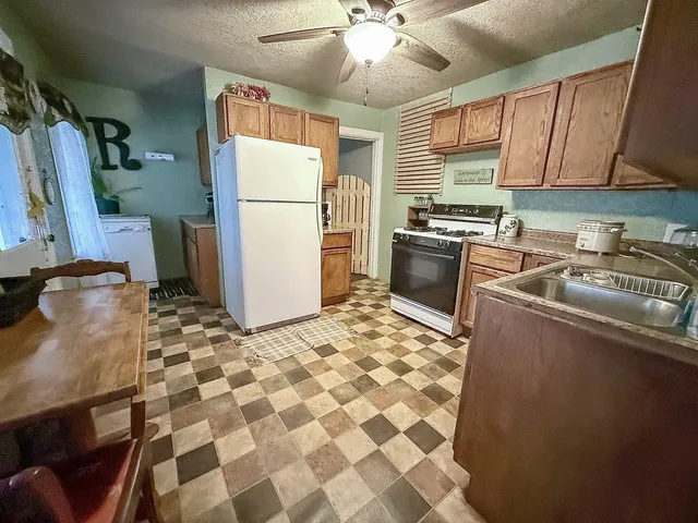 a kitchen with a stove a refrigerator and a sink