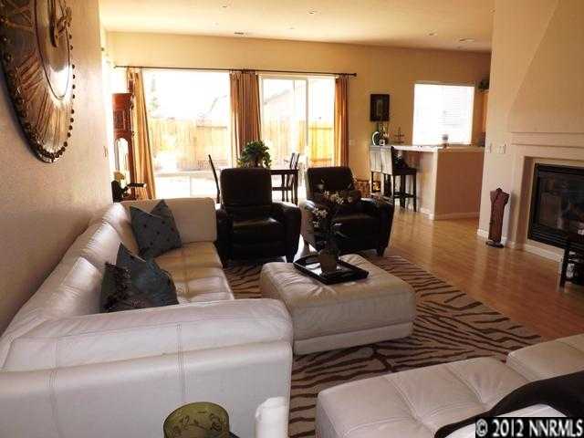 a living room with furniture fireplace and large windows