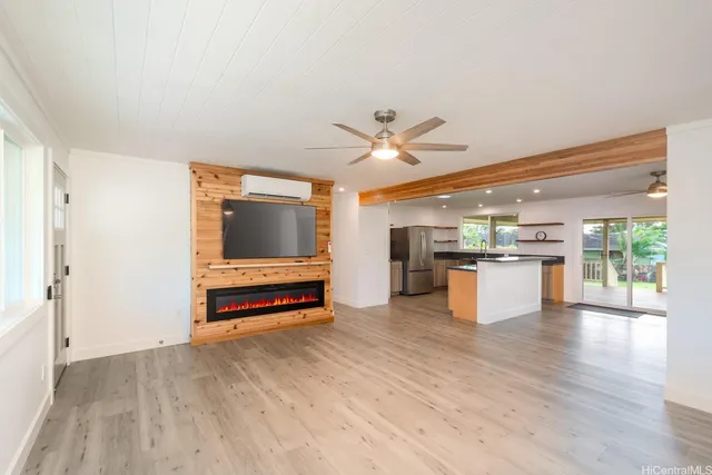a living room with stainless steel appliances furniture and a kitchen view