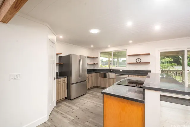 a kitchen with stainless steel appliances granite countertop a refrigerator and a stove top oven