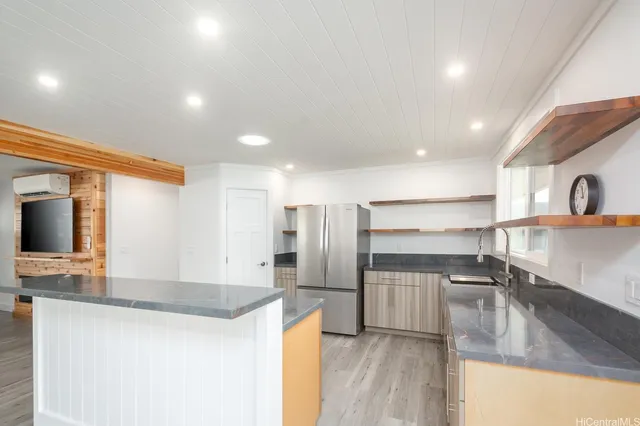 a kitchen with stainless steel appliances granite countertop a sink and a refrigerator