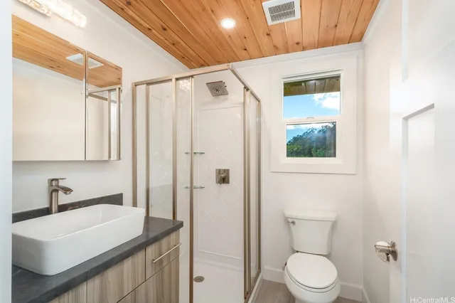 a bathroom with a sink a toilet and shower