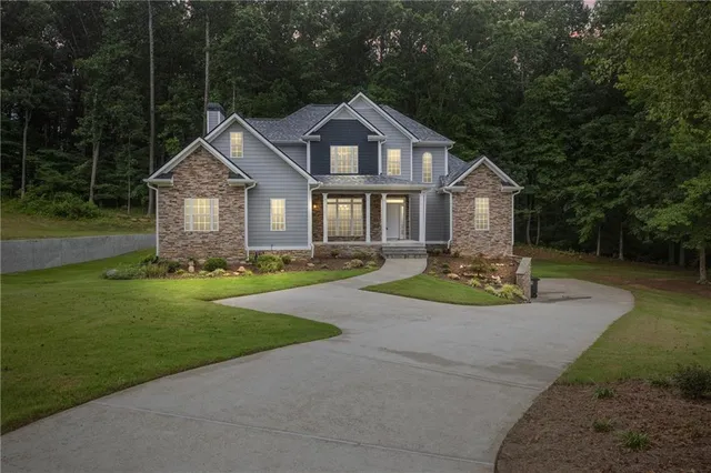 a front view of a house with a garden and trees