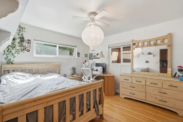 a bedroom with a bed and a wooden floor