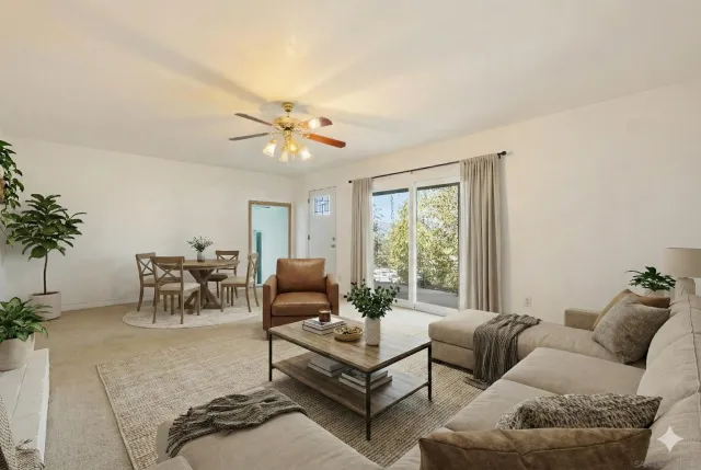 a view of a patio with table and chairs and floor to ceiling window plants and trees
